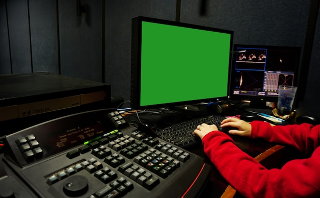 homem edita vídeo em um estúdio escuro usando ferramentas e equipamentos modernos de gradação de cores