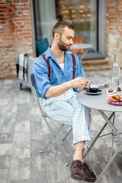 Homem elegante bebe café no café