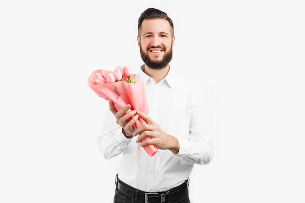 Homem elegante com uma barba segurando um buquê de tulipas, um presente para o dia dos namorados