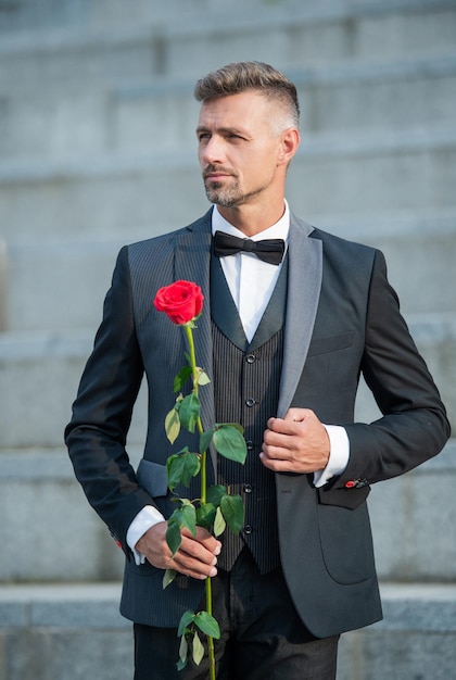 Homem elegante de conceito de ocasião especial com rosa para noiva de ocasião especial em ocasião especial