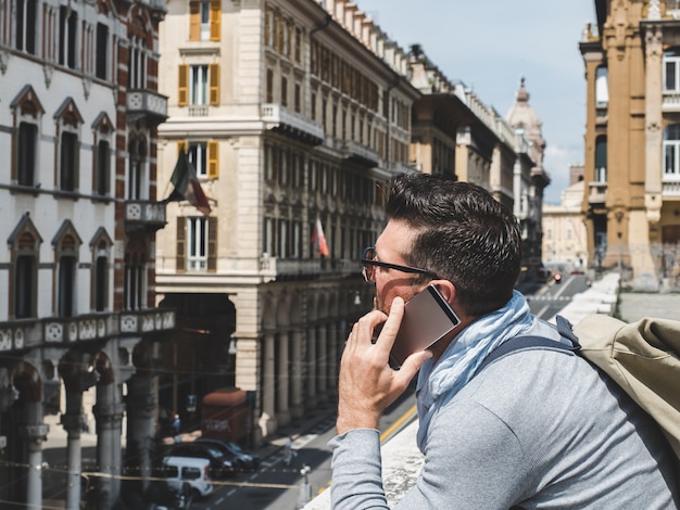 Homem elegante e feliz com um smartphone. lazer, viajar, positivo