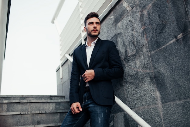 Homem elegante jovem empresário com uma barba em um elegante terno e jeans.