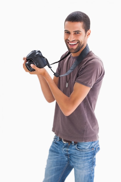 Homem elegante segurando câmera e sorrindo