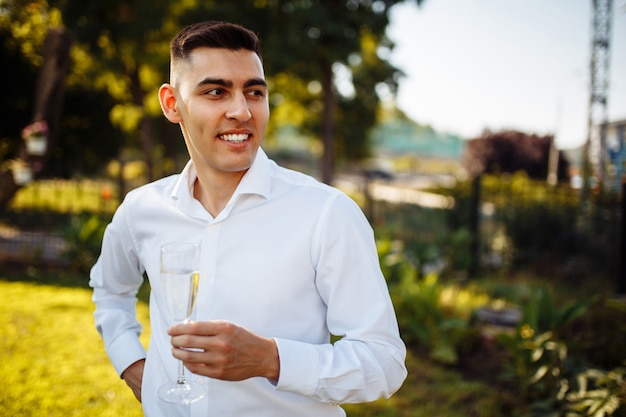 Homem elegante segurando taças de champanhe no casamento de luxo.