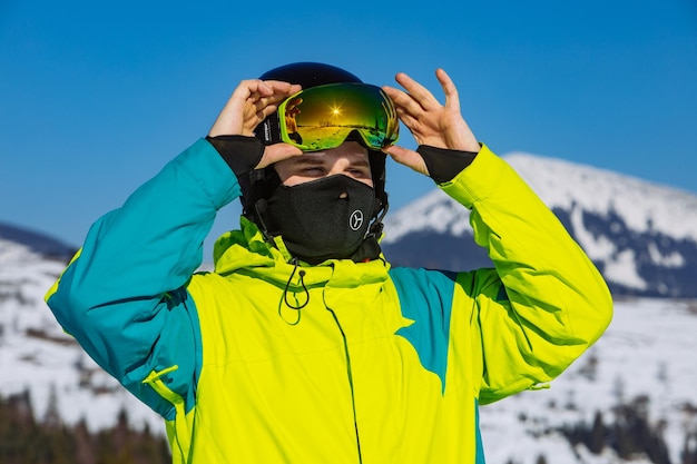 Homem em atividade de inverno de reflexão de máscara de esqui e capacete