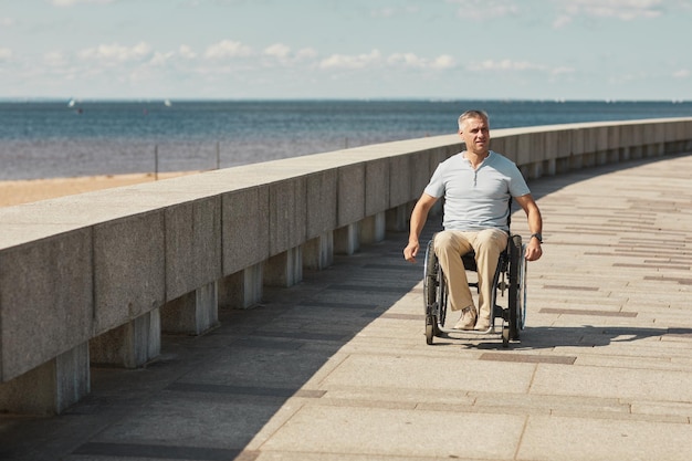Homem em cadeira de rodas à beira-mar