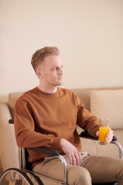 Homem em cadeira de rodas bebendo suco