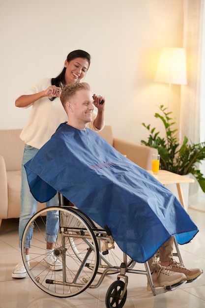 Homem em cadeira de rodas cortando o cabelo