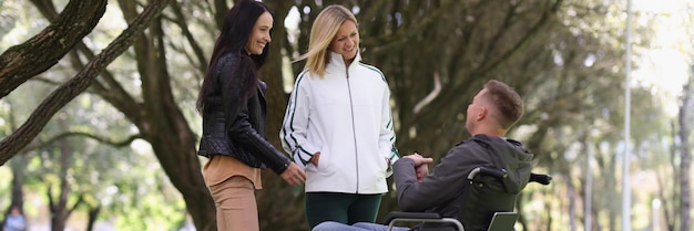 Homem em cadeira de rodas e mulher rindo conversando no parque com amigos de apoio psicológico para