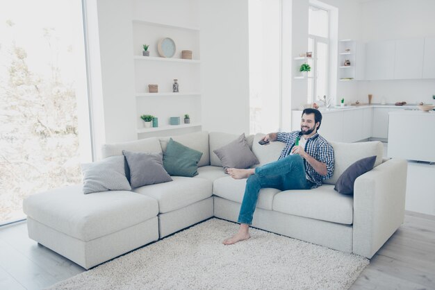 Homem em casa no sofá assistindo tv