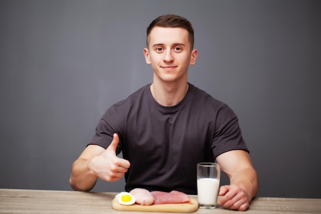 Homem em forma e saudável segurando uma tábua de refeições frescas com carne.