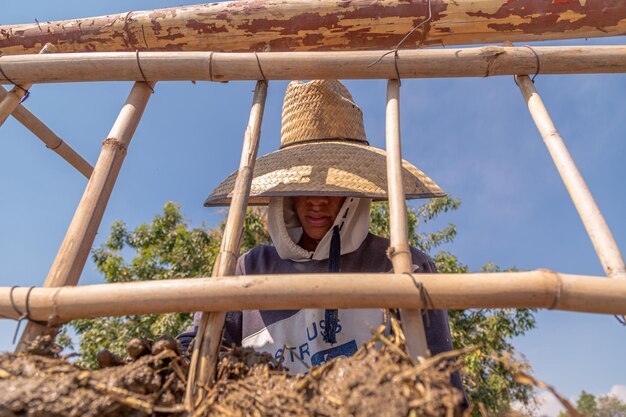 Homem em frente a parede de terra com técnica de bioconstrução