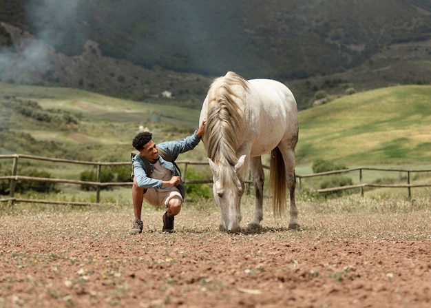 Homem em plena cena fazendo carinho no cavalo