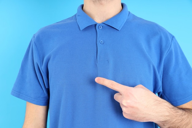 Homem em polo azul em branco sobre fundo azul