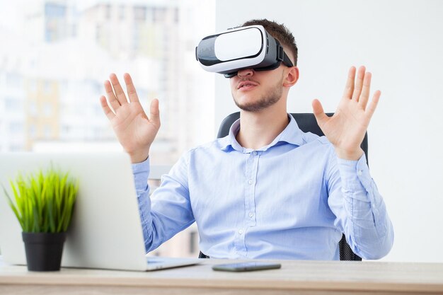 Homem em roupas de escritório e óculos de realidade virtual tocando o ar