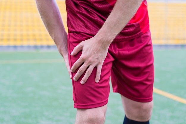 Homem em roupas esportivas segurando o quadril