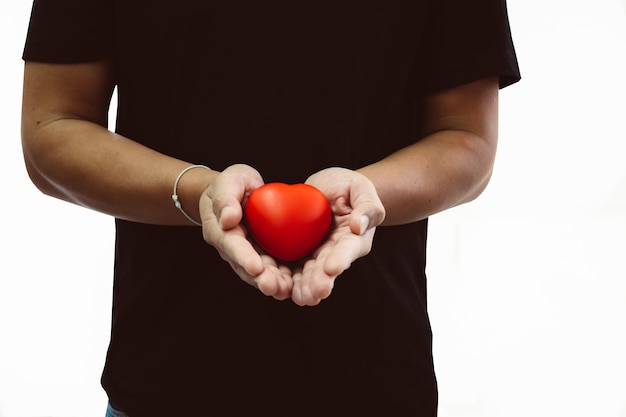 Foto homem, em, t-shirt preta, segurando, coração vermelho, em, seu, mão