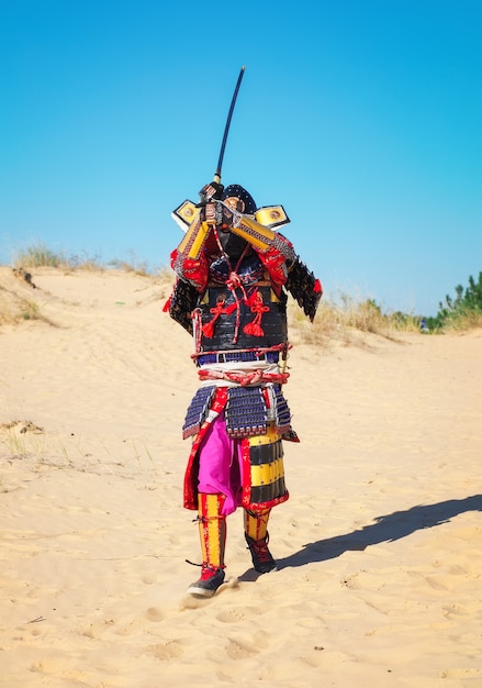 Foto homem em traje de samurai com espada indo para o ataque