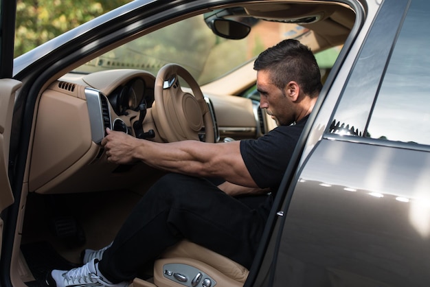 Homem em um agasalho dirigindo no carro