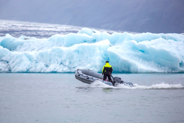 Homem em um barco a motor veloz navegando em uma lagoa glaciar na islândia