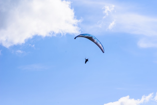 Homem em um para-quedas voando no céu claro