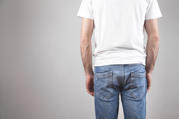 Homem em uma camiseta branca e jeans.