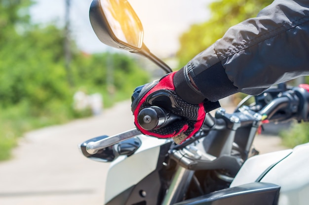 Homem em uma motocicleta com luvas é uma importante roupa de proteção para o motociclismo