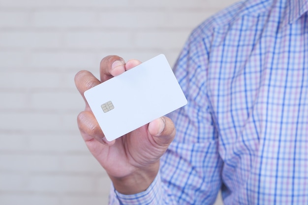 Homem em vestido casual mostrando cartão de crédito