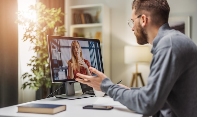 Homem em videochamada com colega