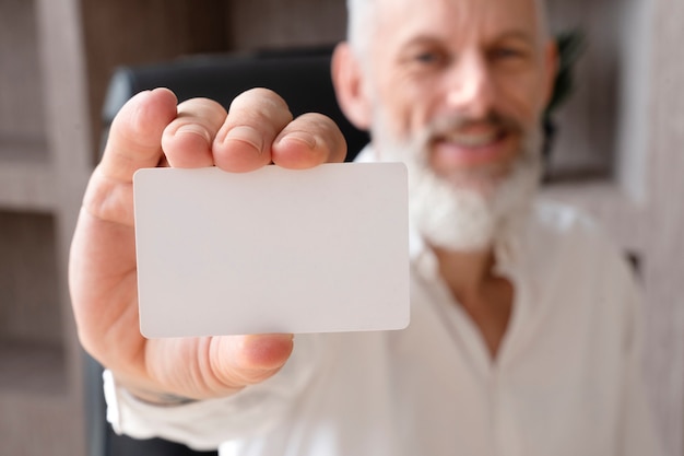 Foto homem embaçado sorridente segurando o cartão de visita