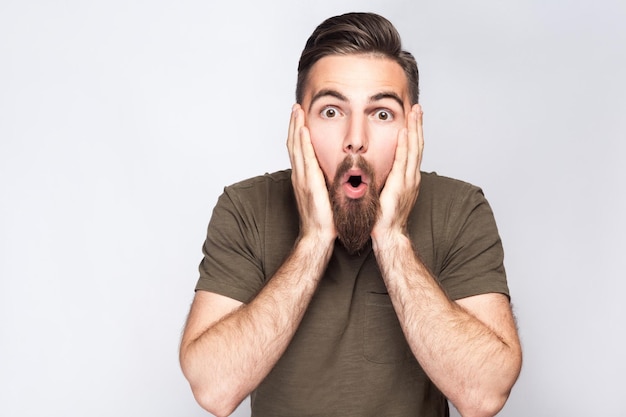 Homem emocional com camiseta verde sobre fundo cinza