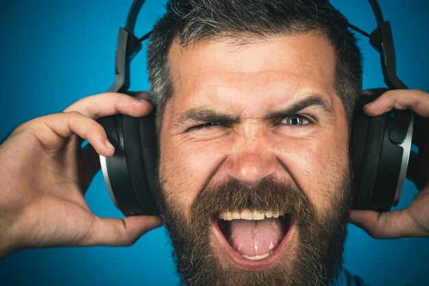 Homem emocional com fones de ouvido ouvindo música closeup retrato elegante homem feliz ouvindo música