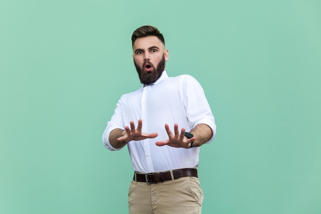 Homem emocional em camisa branca perto de fundo verde