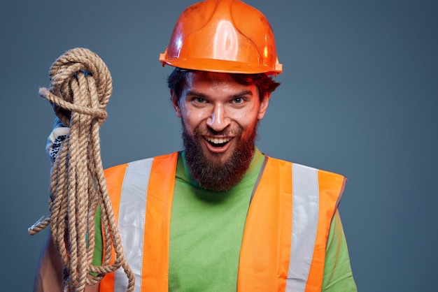 Homem emocional em uniforme de trabalho laranja capacete corda profissional