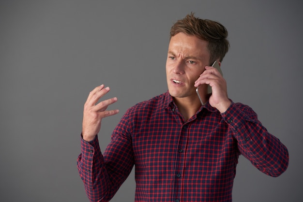 Foto homem emocional falando ao telefone