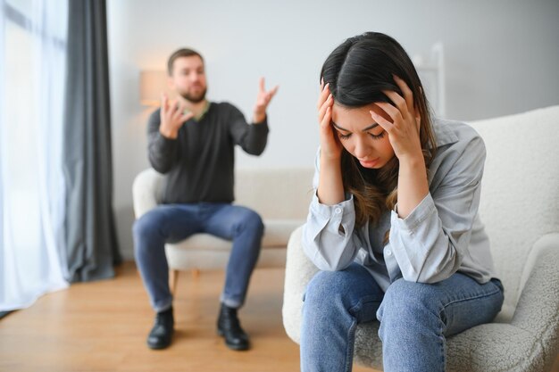 Homem emocional gesticulando e gritando com sua esposa casal jovem tendo briga em casa conceito de abuso doméstico