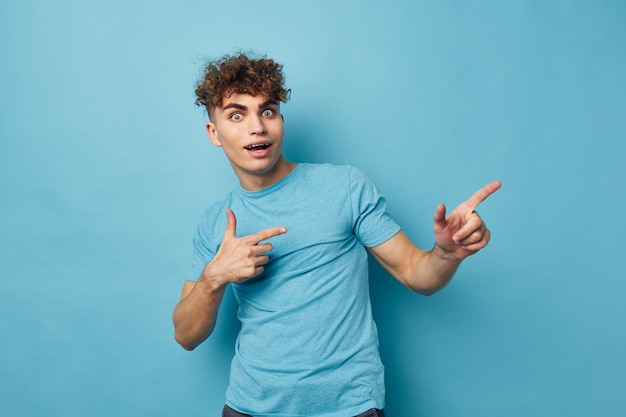 Homem encaracolado com uma camiseta em um fundo colorido posando