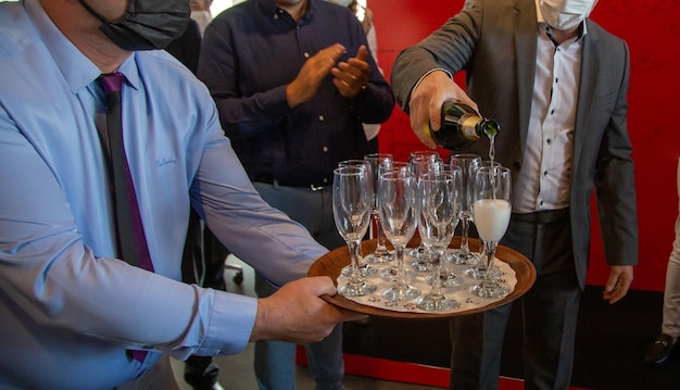 Homem enchendo a taça de champanhe na celebração