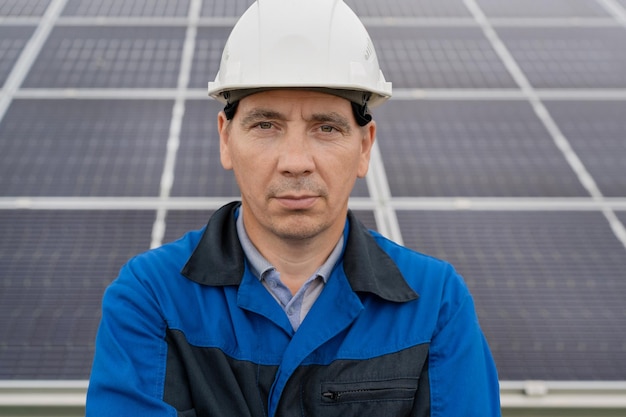 Homem engenheiro de serviço em pé com os braços cruzados na frente do técnico de manutenção de painéis solares sola