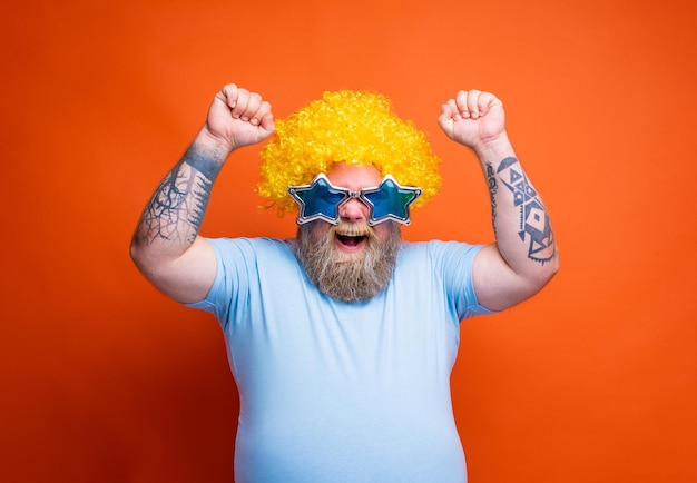 Foto homem engraçado com peruca e óculos de sol está feliz e exulta por algo
