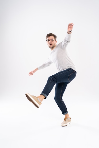 Homem engraçado em camiseta casual e jeans pulando isolado sobre fundo branco