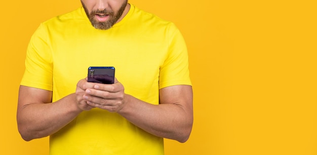 Homem enviando mensagens de texto no telefone isolado no banner amarelo homem enviando mensagens de texto no telefone em segundo plano