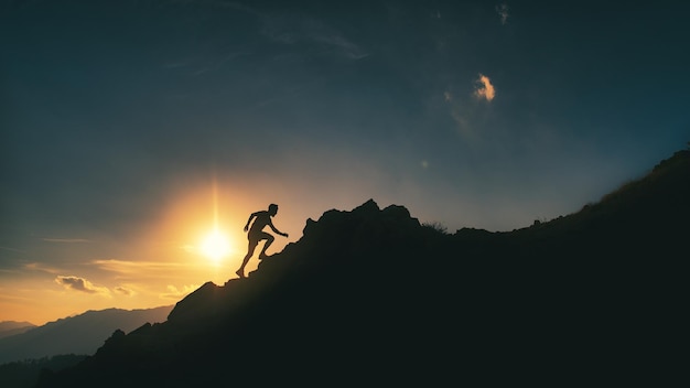 Homem escala um cume de montanha rochosa em um pôr do sol pitoresco