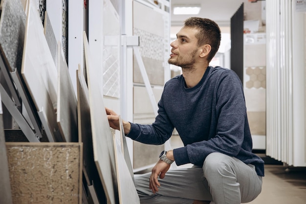 Homem escolhendo azulejos no mercado de construção