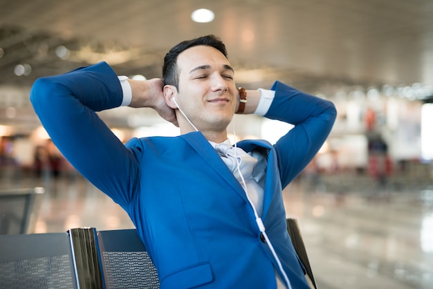 Foto homem, escutar música, enquanto, esperando, em, um, aeroporto