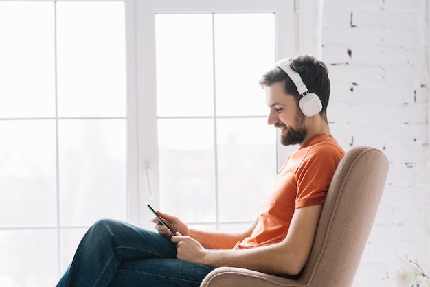 Foto homem, escutar música, perto, janela