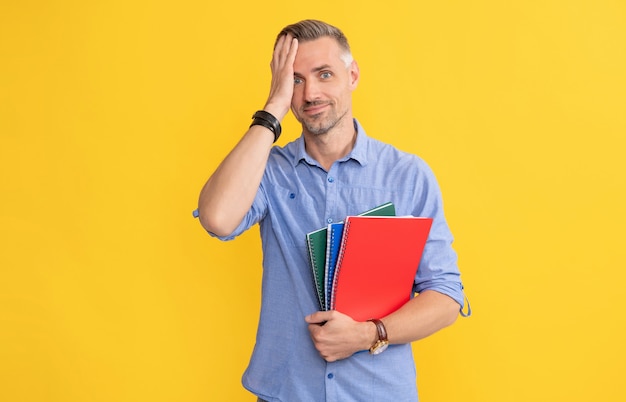 Homem espantado com caderno escolar ou planejador, universidade.