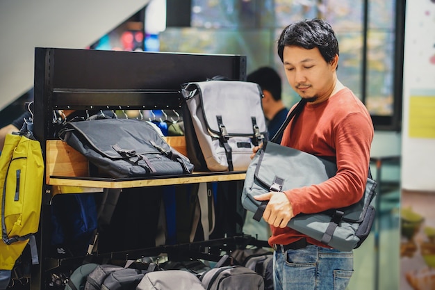 Homem esperto, com, barba, tentando, saco, e, fazendo decisão, em, moda, sacolas, loja, em, centro comercial