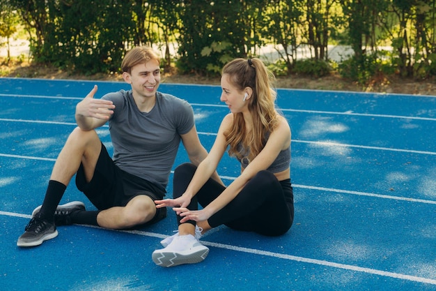 Homem esportivo e mulher falando no campo de esportes