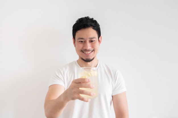 Homem está bebendo refrigerante de limão gelado em fundo branco isolado.